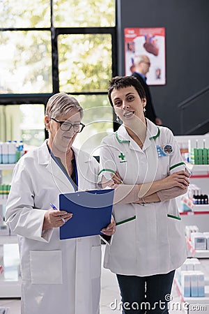 Two smiling woman pharmacy specialists in drugstore portrait Stock Photo