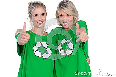 Two smiling women wearing green recycling tshirts giving thumbs up Stock Photo