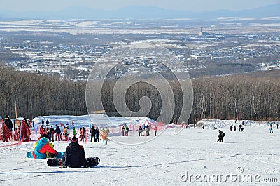 Arsenyev, Russia, January, 28, 2017. Two snowboarders siting on the teaching slope. Ski resort in the town of Arsenyev. Editorial Stock Photo