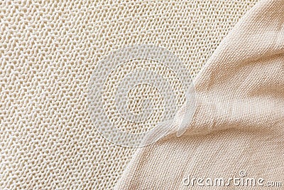 Two soft beige knitted blankets lying diagonally with copy space Stock Photo