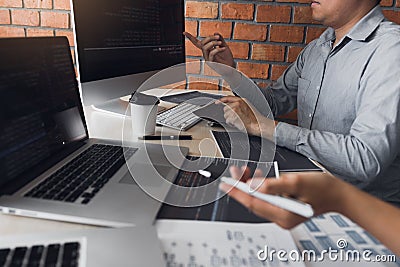 Two software developers are analyzing together about the code written into the program on the computer Stock Photo