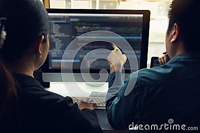 Two software developers are analyzing together about the code written into the program on the computer Stock Photo