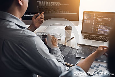 Two software developers are using computers to work together with their partner at the office desk Stock Photo