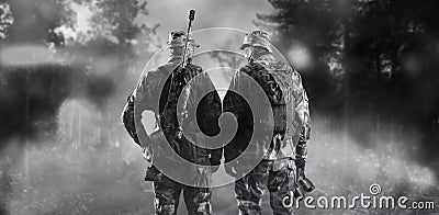 Two soldiers of a special unit are standing in a smoky forest. Stock Photo