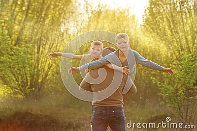 Two sons and his spring in winter forest, outdoor portrait. Father holding two sons. fun, joy, happiness, friendship Stock Photo