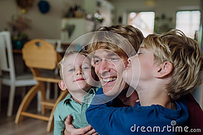 Two sons kissing father's cheeks. Concept of Father's Day, and fatherly love. Stock Photo