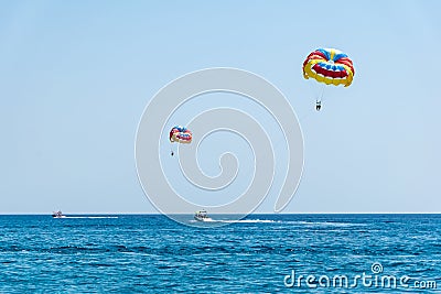 Two speed boats with people flying on parasailing parachute RHO Stock Photo