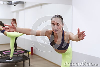 two sports girls are engaged in jumping on sports trampoline Stock Photo