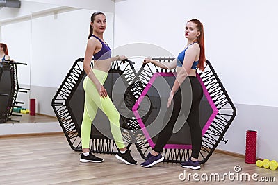 two sports girls are engaged in jumping on sports trampoline Stock Photo