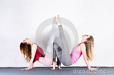 Two sports girls train yoga in a fitness class. Pair of young women stretching Stock Photo