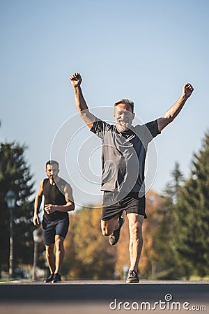 The two sportsmen running on the park road. Stock Photo