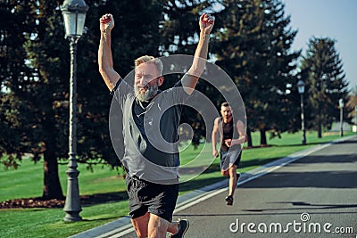 The two sportsmen running on the road. Stock Photo