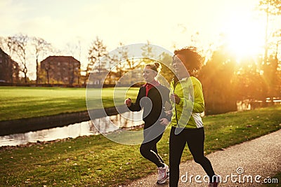 Two sportswomen running in park Stock Photo
