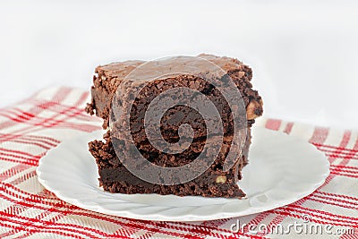Two stacked chocolate fudge walnut brownies on a plate. Shallow focus Stock Photo