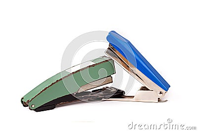 Two staplers fighting, stapling, biting each other. New vs old fight, new winning Office war, desk accessories duel, brawl Stock Photo