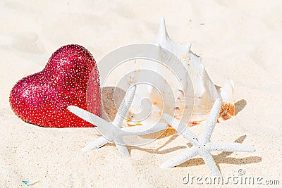 Two starfish, big red heart and large shell on a sandy tropical Stock Photo