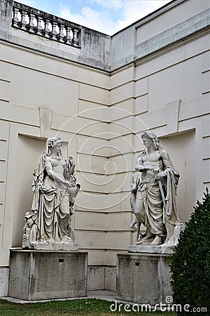 Two statues, a man and a woman, seem to look at each other as if they were talking, in a corner of a garden in Vienna. Stock Photo