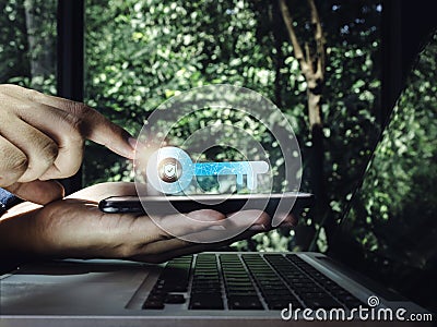 Two steps authentication concept. Virtual key icon on smartphone in hand with laptop for validate password, Identity verification. Stock Photo