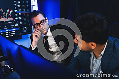 Two stock exchange traders discussing market on data monitor. Sellable. Stock Photo