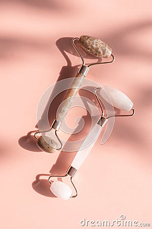 Two stone jade rollers on pink background Stock Photo