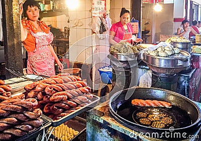 Two street vendors are selling Chinese traditional food in an open market in China Editorial Stock Photo