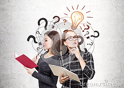 Two students with books, question marks and bulb Stock Photo