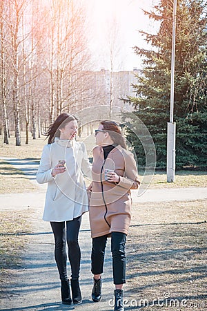 Two stylish and glamorous girls are walking in the spring park Stock Photo