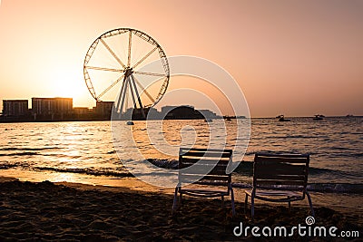 Two sunbeds with Ain Dubai ferris wheel view at JBR beach Stock Photo