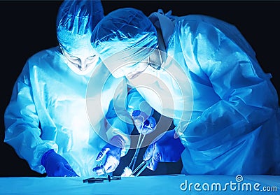 Two surgeons, a man and a woman, perform surgery to remove prostate adenoma and varicocele, fibroadenoma Stock Photo