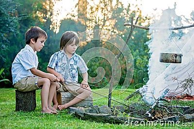 Two sweet children, boy brothers, camping outside summertime on Stock Photo