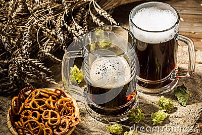 Two tankard beer with wheat and hops , basket of pretzels Stock Photo