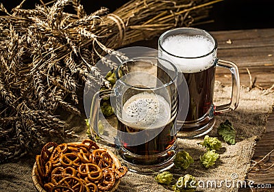 Two tankard beer with wheat and hops , basket of pretzels Stock Photo