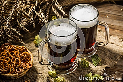 Two tankard beer with wheat and hops , basket of pretzels Stock Photo