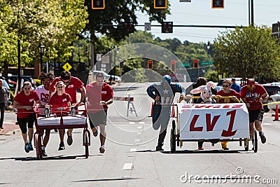 Two Teams Push Beds Down Street In Charity Fundraiser Event Editorial Stock Photo
