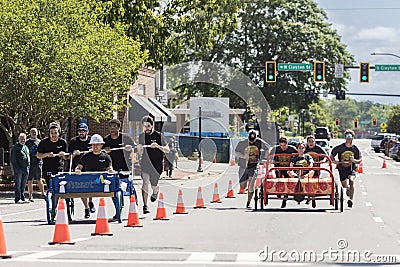 Two teams push beds down street in charity fundraising event Editorial Stock Photo