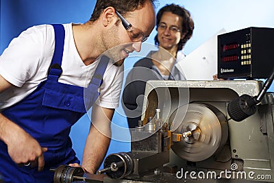 Two technicians on lathe machine in workshop Stock Photo