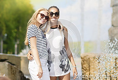 Two Teenage Girlfriends Together. Posing Against Fountain in Park Outdoors Stock Photo