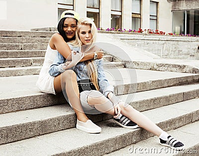 Two teenage girls infront of university building smiling, having Stock Photo