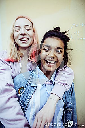 Two teenage girls infront of university building smiling, having Stock Photo