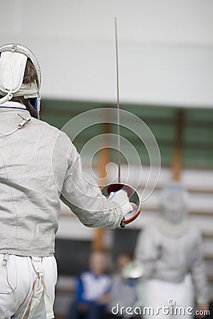 Two teenager fencers fighting with rapiers on the fencing tournament Stock Photo