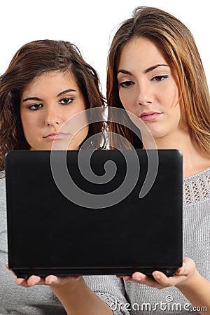 Two teenager girls bored watching a netbook computer Stock Photo