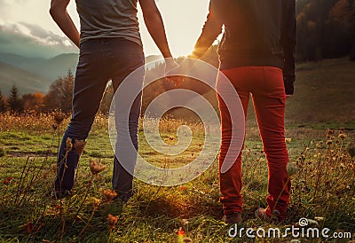 Two teens hand in hand romantic walk by the autumnal mountains Stock Photo