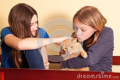 Two teens with orange cat Stock Photo