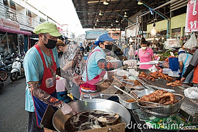Two Thai vendors sell grilled chicken at the market Editorial Stock Photo