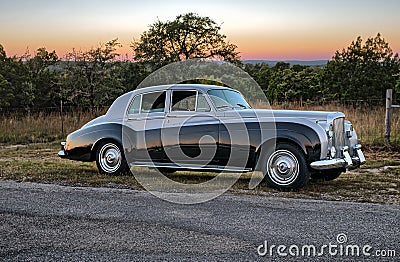 Sunset behind vintage luxery limousine on a Texas country road. Stock Photo