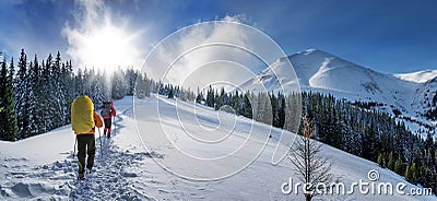 Two tourists climb the snow-covered winter mountain Stock Photo