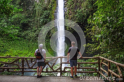 Two tourists looking at the La Fortuna Waterfall in Costa Rica Stock Photo