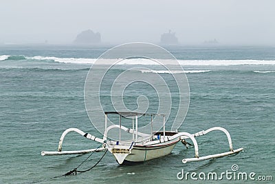 Two traditional Bali fishing boats on big waves in storm and raining Stock Photo
