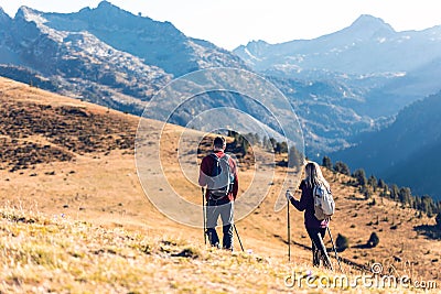 Two travel hikers with backpack walking while looking the landscape in the mountain. Back view Stock Photo