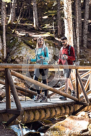 Two travel hikers with backpack walking on the wood bridge while looking the landscape in the forest Stock Photo